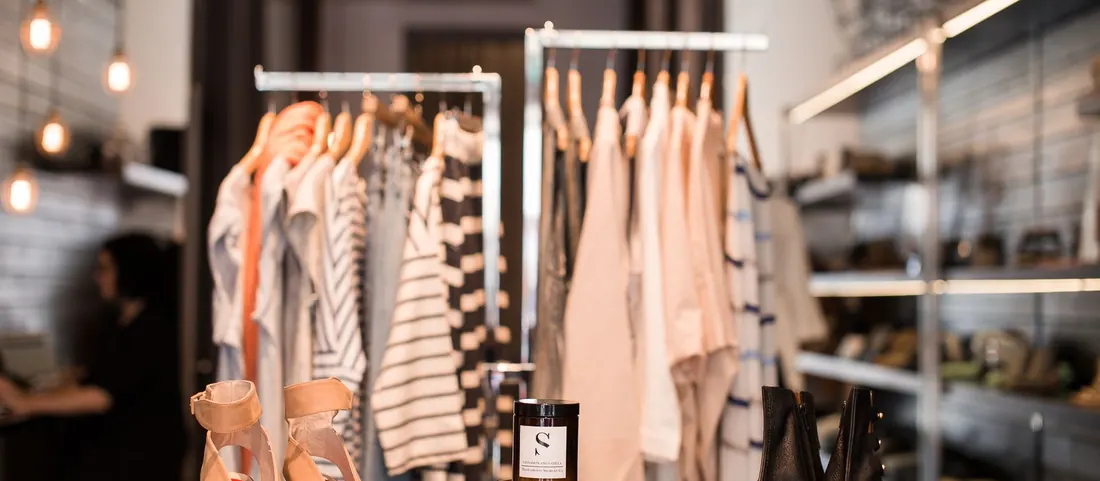 Boutique interior with clothing racks and shoes on a display table