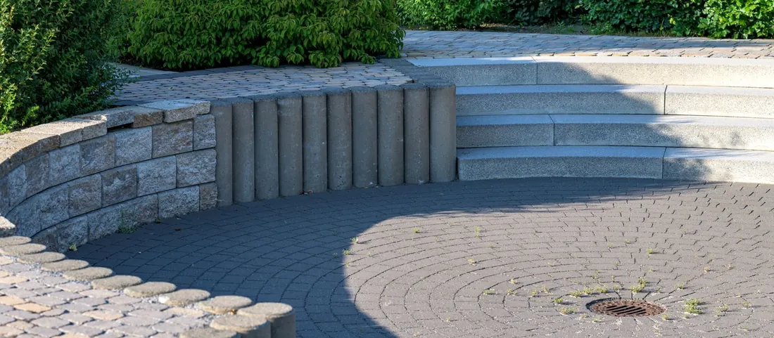 Paver patio with a curved block retaining wall and stone steps