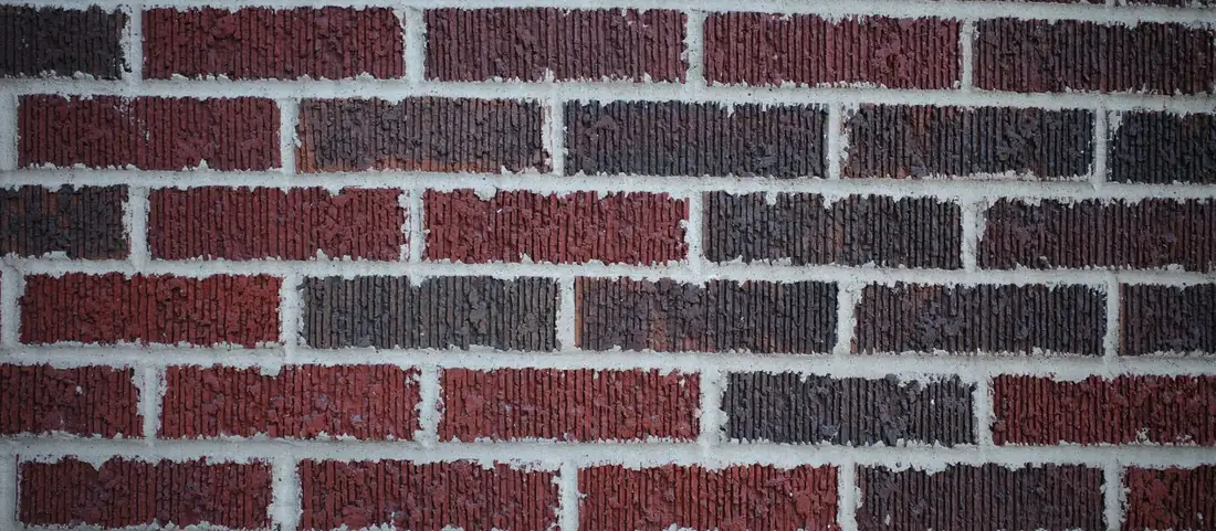 Close view of a red brick wall with pale raked mortar joints