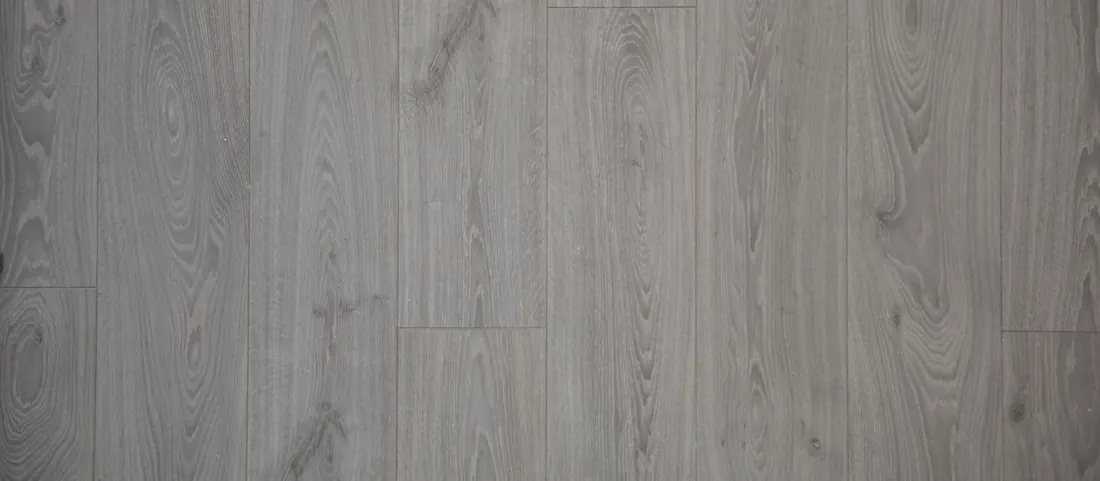 Grey wood look vinyl planks in a staggered run with the plank seams clearly visible
